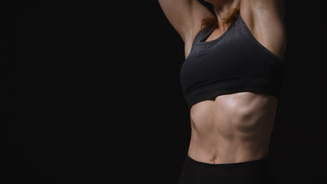 Close-Up-Studio-Shot-Showing-Abdomen-Of-Mature-Woman-Wearing-Gym-Fitness-Clothing-Doing-Stretching-Exercises